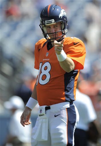 Peyton Manning in his new Broncos jersey flanked by Eli Manning