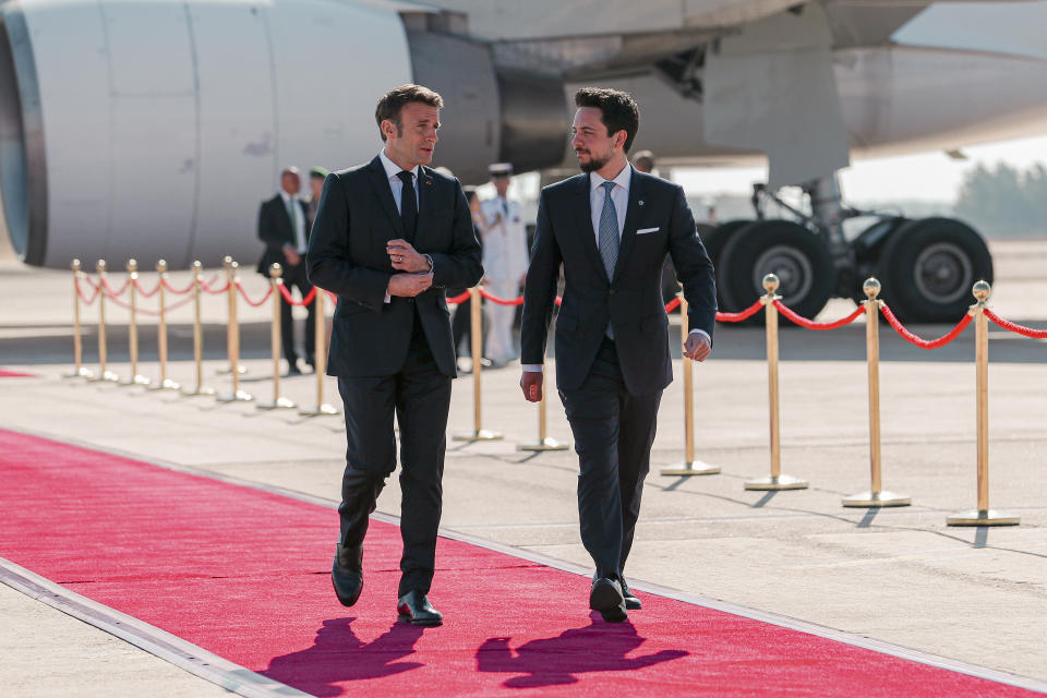 Jordan's Crown Prince Hussein and French President Emmanuel Macron attend a welcome ceremony at the airport in Amman, Jordan, Tuesday, Dec. 20, 2022. Leaders from the Middle East and Europe gathered in Jordan Tuesday in a conference focused on bolstering security and stability in Iraq. (The Royal Hashemite Court via AP)