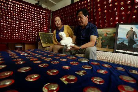 A man holds a statue of China's late Chairman Mao Zedong, as he presents his collections at his home, ahead of Mao's 40th death anniversary, in Zhangye, Gansu Province, China, September 8, 2016. REUTERS/Stringer
