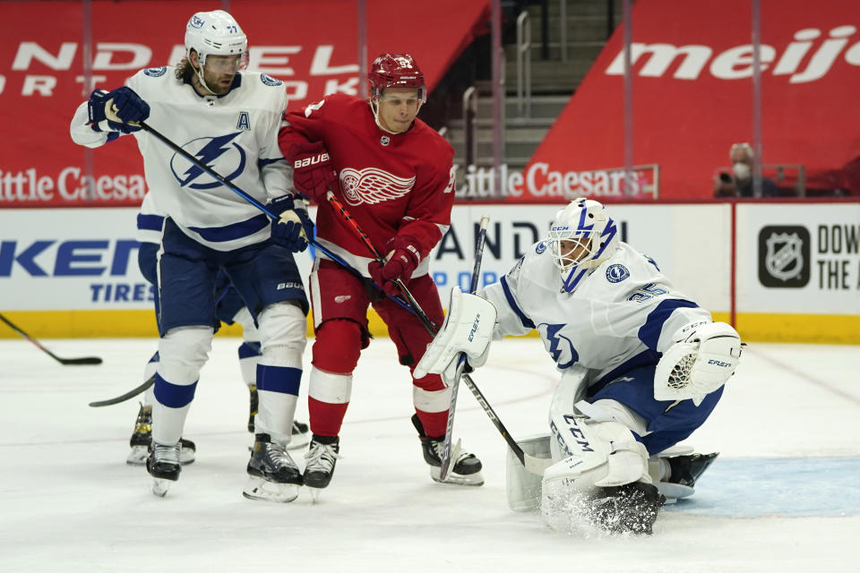 Tampa Bay Lightning goaltender Curtis McElhinney (35) stops a shot as Detroit Red Wings center Vladislav Namestnikov (92) watches for a rebound as Victor Hedman (77) defends in the second period of an NHL hockey game Saturday, May 1, 2021, in Detroit. (AP Photo/Paul Sancya)