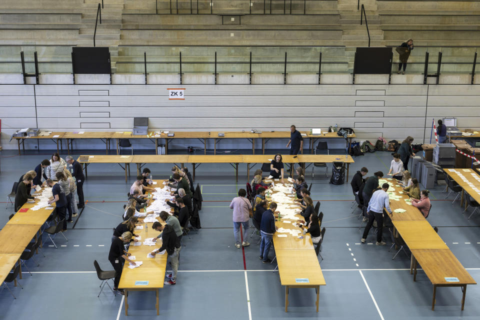 Election counting staff count the votes at a polling station in Berne, Switzerland, Sunday, Oct. 22, 2023. The anti-immigration Swiss People’s Party rebounded from searing losses four years ago, expanding its hold as the largest parliamentary faction, while environmentally-minded parties lost ground despite record glacier melt in the Alpine country, official election results showed. (Alessandro della Valle/Keystone via AP)