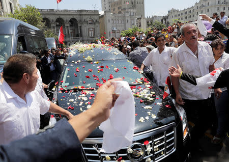 The hearse carrying the remains of Peru's former President Alan Garcia, who killed himself this week, makes its way through the crowd of supporters, in Lima, Peru April 19, 2019. REUTERS/Guadalupe Pardo