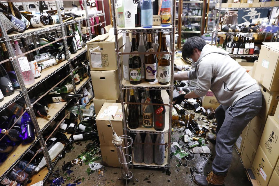 A liquor shop's manager clears the damaged bottles following an earthquake in Fukushima, northeastern Japan Saturday, Feb. 13, 2021. The Japan Meteorological Agency says a strong earthquake has hit off the coast of northeastern Japan, shaking Fukushima, Miyagi and other areas. (Jun Hirata/Kyodo News via AP)