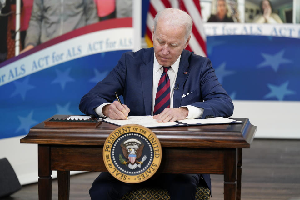 President Joe Biden signs the "Accelerating Access to Critical Therapies for ALS Act" into law during a ceremony in the South Court Auditorium on the White House campus in Washington, Thursday, Dec. 23, 2021. (AP Photo/Patrick Semansky)