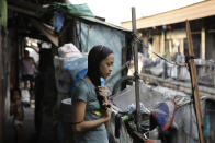 In this photo taken Dec. 4, 2012, Filipino slum dweller Jessa Balote holds her hair outside her cramped home at a place called Aroma in Tondo, Manila, Philippines. Balote, who used to tag along with her family as they collect garbage at a nearby dumpsite, is a scholar at Ballet Manila's dance program. As an apprentice, she makes around 7,000 pesos ($170) a month, sometimes double that, from stipend and performance fees. (AP Photo/Aaron Favila)