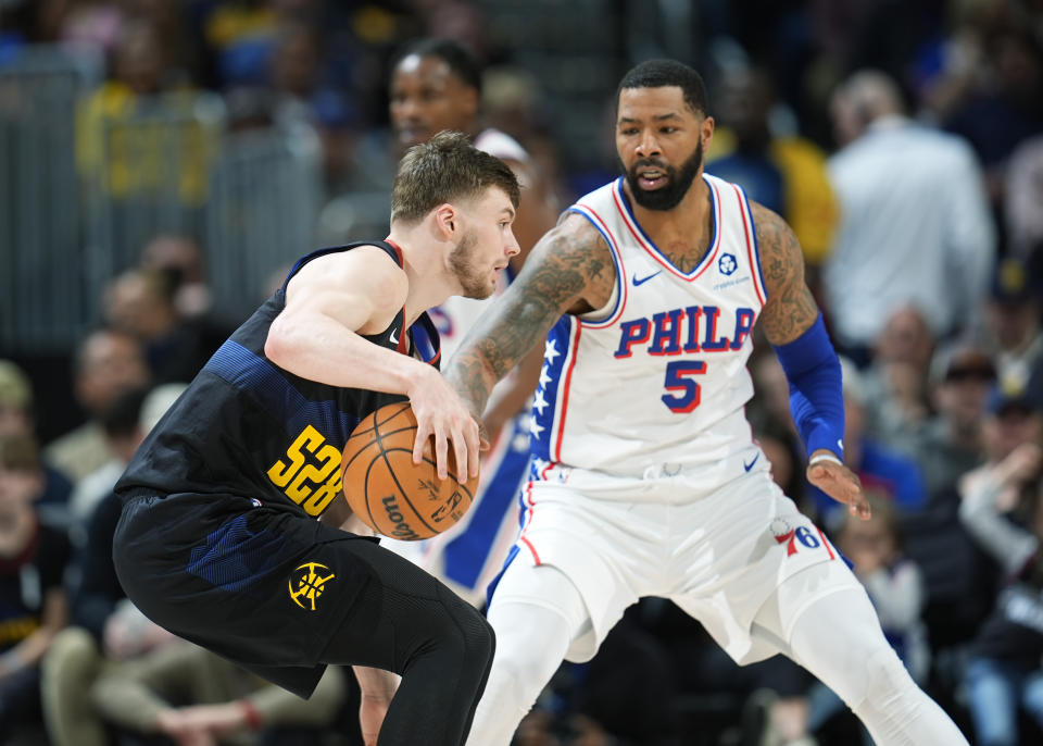 Denver Nuggets guard Christian Braun, left, drives to the basket as Philadelphia 76ers forward Marcus Morris Sr. defends in the first half of an NBA basketball game Saturday, Jan. 27, 2024, in Denver. (AP Photo/David Zalubowski)