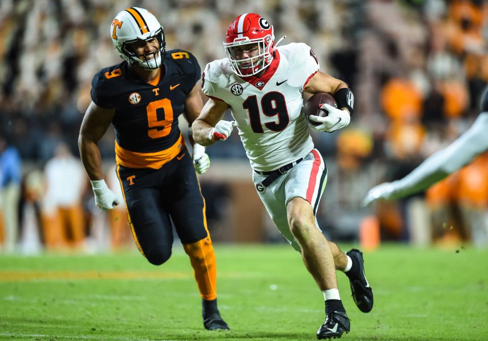 Georgia tight end Brock Bowers (19) runs away from Tennessee linebacker Tyler Baron (9) during the second half of their 2021 game at Neyland Stadium.
