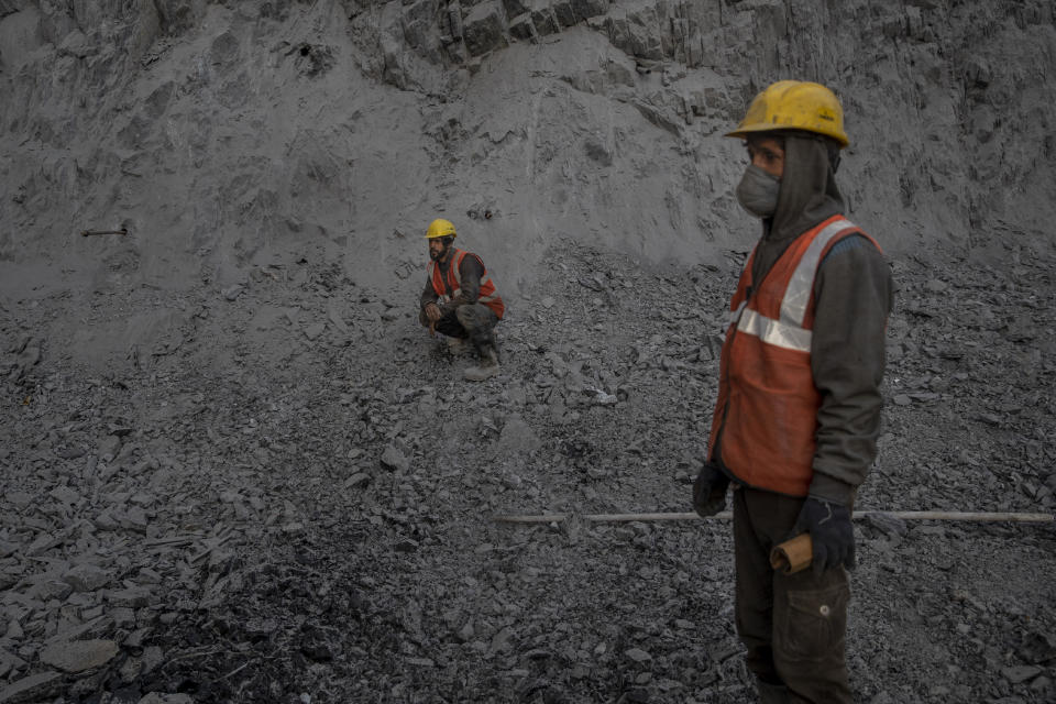 Workers watch from distance as others drill a hole in the mountain at the entrance of Nilgrar Tunnel in Baltal area, northeast of Srinagar, Indian controlled Kashmir, Tuesday, Sept. 28, 2021. High in a rocky Himalayan mountain range, hundreds of people are working on an ambitious project to drill tunnels and construct bridges to connect the Kashmir Valley with Ladakh, a cold-desert region isolated half the year because of massive snowfall. The $932 million project’s last tunnel, about 14 kilometers (9 miles) long, will bypass the challenging Zojila pass and connect Sonamarg with Ladakh. Officials say it will be India’s longest and highest tunnel at 11,500 feet (3,485 meters). (AP Photo/Dar Yasin)