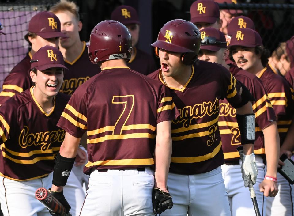 Bloomington North’s Jack Leonard (31) celebrates with Luke Freel (7) after Freel scored during the baseball game at South on Thursday, April 25, 2024.