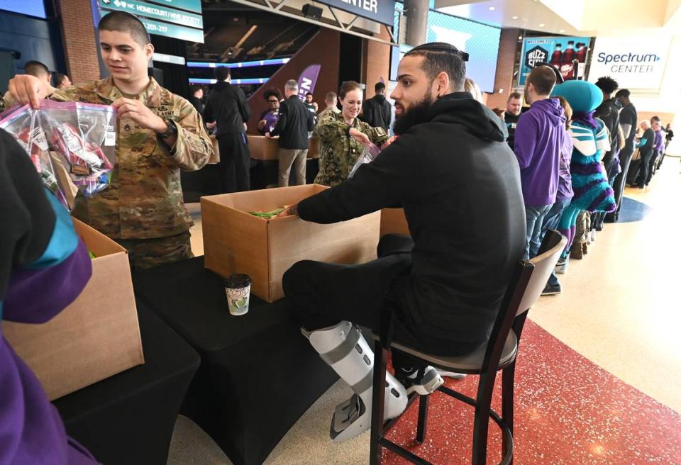 Charlotte Hornets guard/forward Cody Martin, center, wears a walking boot on his left leg during the team and Novant Health’s Military Care event at Spectrum Center on Monday, March 4, 2024. JEFF SINER/jsiner@charlotteobserver.com