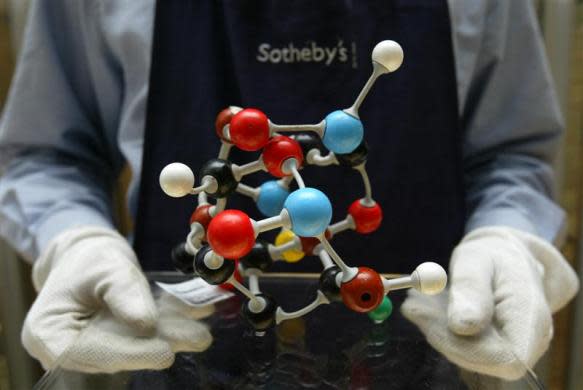 An auctioneer's assistant holds up the artwork 'Molecular Structure' by British artist Damien Hirst at Sotheby's in London, October 14, 2004.