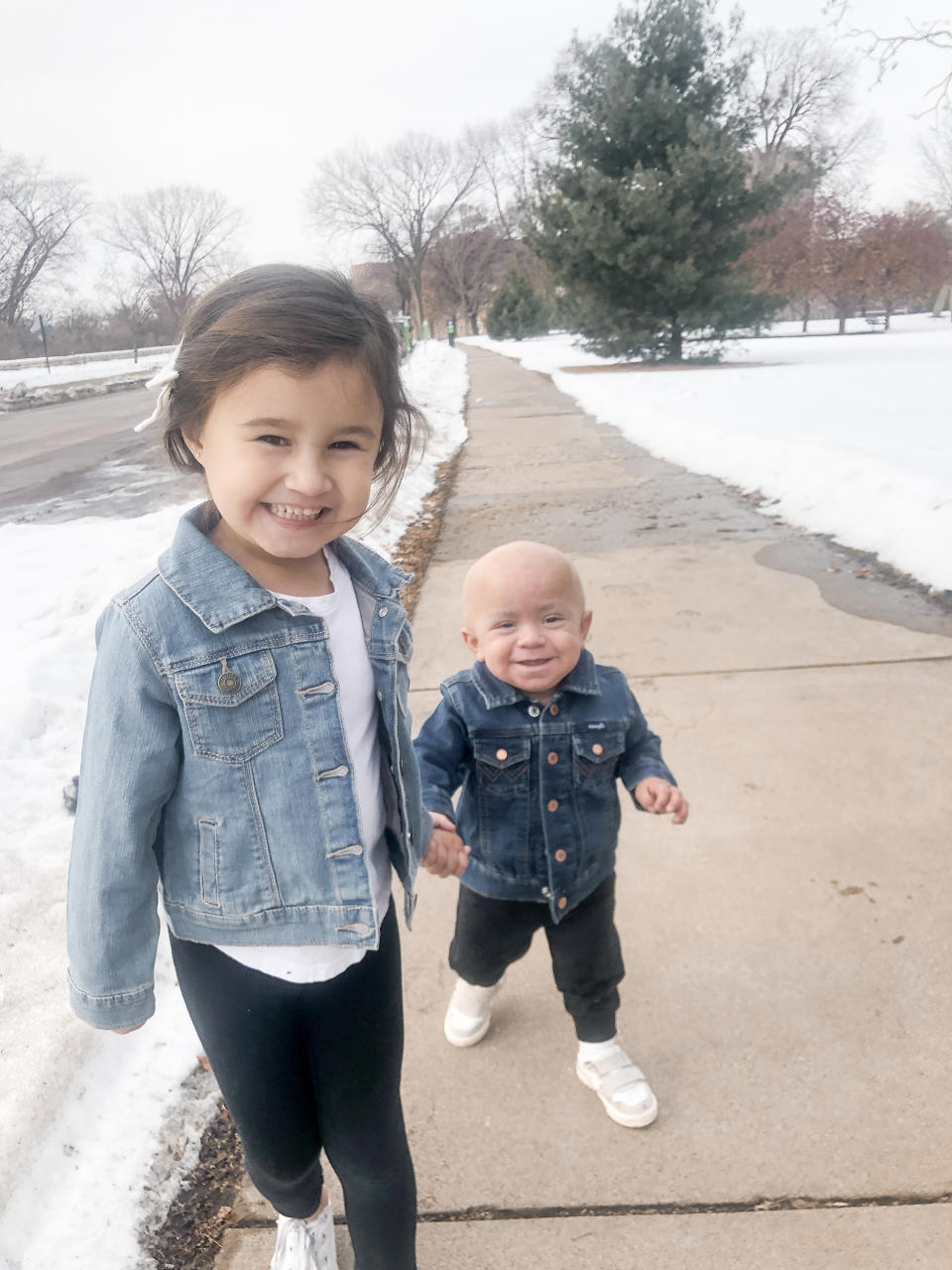 Olivia Vasquez holds her brother's hand during their stay in Minneapolis, Minnesota, last year where baby Eli received bone marrow donated by his sister. He lost his hair and suffered other side effects from chemotherapy necessary before the transplant. (Courtesy Vasquez family)
