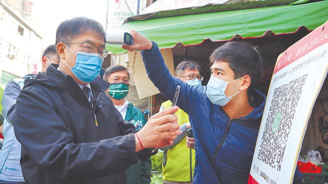 台南市長黃偉哲（左）昨天一早前往新營第一市場視察防疫作為，入場前用手機掃實聯制QR-Code。（張毓翎攝）