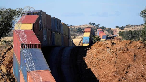 PHOTO: A long row of double-stacked shipping contrainers provide a new wall between the United States and Mexico in the remote section area of San Rafael Valley, Ariz., Dec. 8, 2022. (Ross D. Franklin/AP)