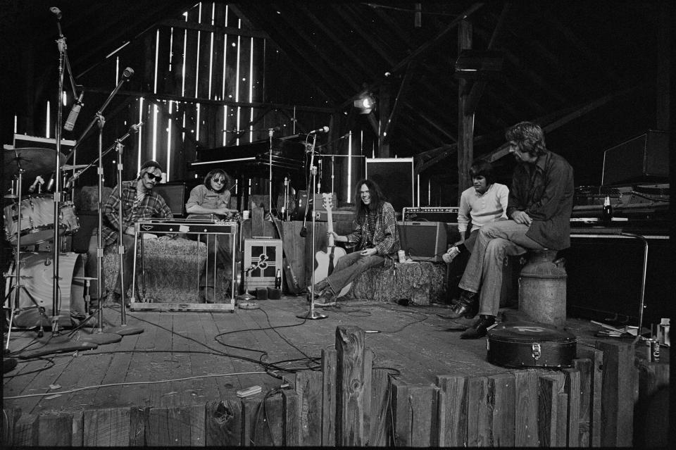 Neil Young & the Stray Gators, relaxing onstage between takes in the barn, Broken Arrow ranch, near Woodside, CA, Sept. 1971.