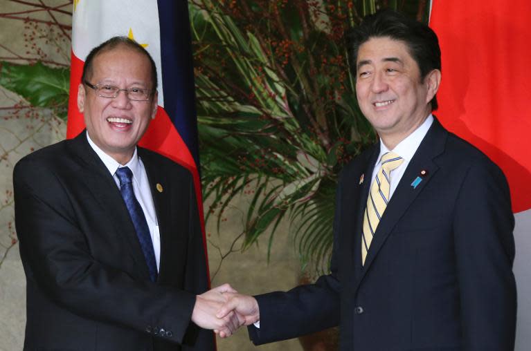 Japanese Prime Minister Shinzo Abe (R) greets Philippines' President Benigno Aquino the Abe's official residence in Tokyo, on December 13, 2013