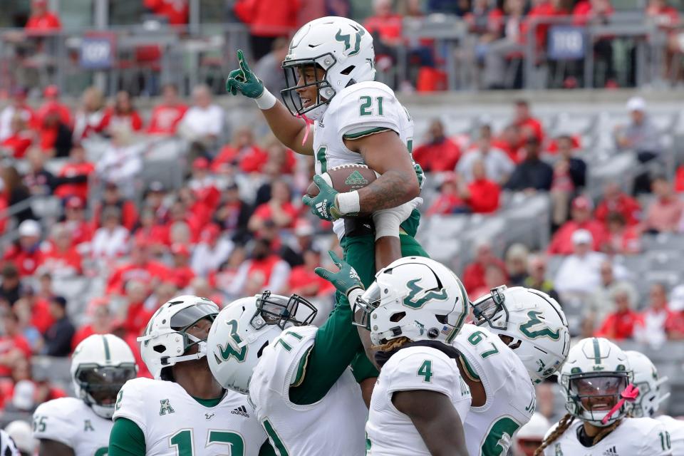 South Florida running back Brian Battie (21) is hoisted up by South Florida offensive lineman Derrell Bailey Jr. (71) to celebrate Battie's touchdown against Houston during the first half of an NCAA college football game Saturday, Oct. 29, 2022, in Houston. (AP Photo/Michael Wyke)