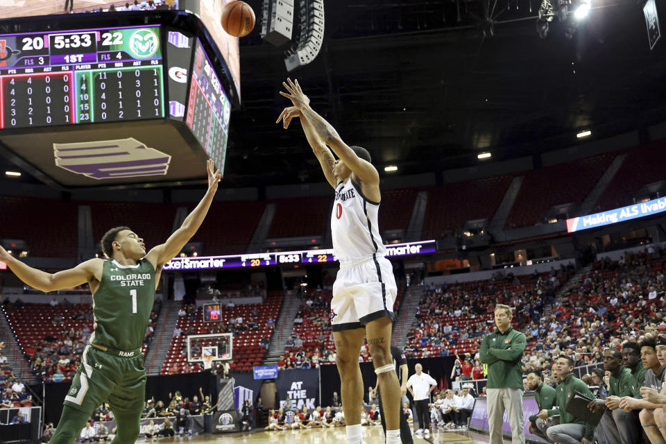 San Diego State forward Keshad Johnson (0) shoots for the basket over Colorado State guard John Tonje (1) during the first half of an NCAA college basketball game in the quarterfinals of the Mountain West Conference Tournament, Thursday, March 9, 2023, in Las Vegas. (AP Photo/Ronda Churchill)