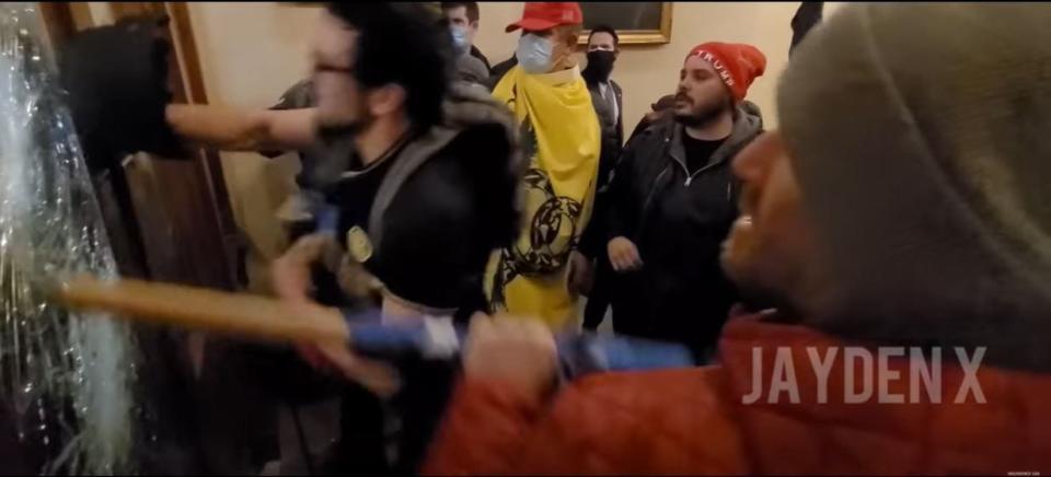 Chad Barrett Jones, of Mount Washington, is seen on another protester's video using a rolled up flag to smash the door the to Speaker's Hallway during riots at the U.S. Capitol on Jan. 6. He faces nine federal charges, including assaulting an officer.