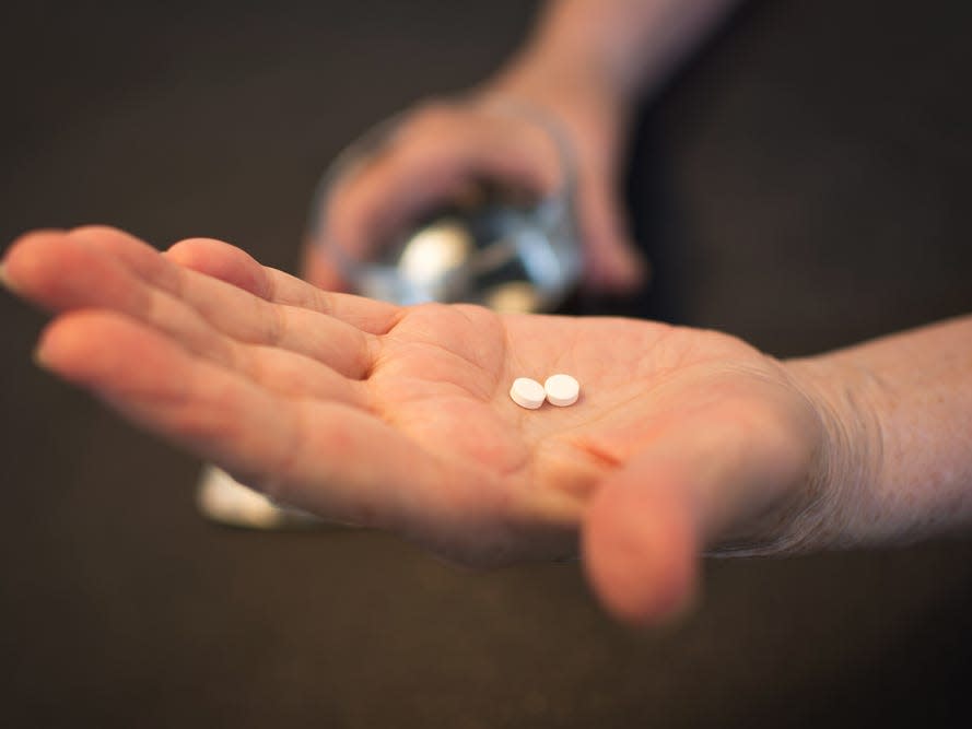 woman holding pills in hand