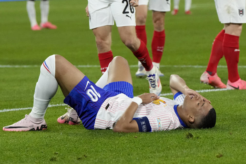 Kylian Mbappe of France lies on the pitch during a Group D match between Austria and France at the Euro 2024 soccer tournament in Duesseldorf, Germany, Monday, June 17, 2024. (AP Photo/Martin Meissner)