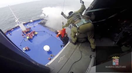 A person is lifted on an Italian Navy helicopter as the car ferry Norman Atlantic burns in waters off Greece December 28, 2014 in this handout video grab of the Italian Marina Militare. REUTERS/Marina Militare/Handout via Reuters
