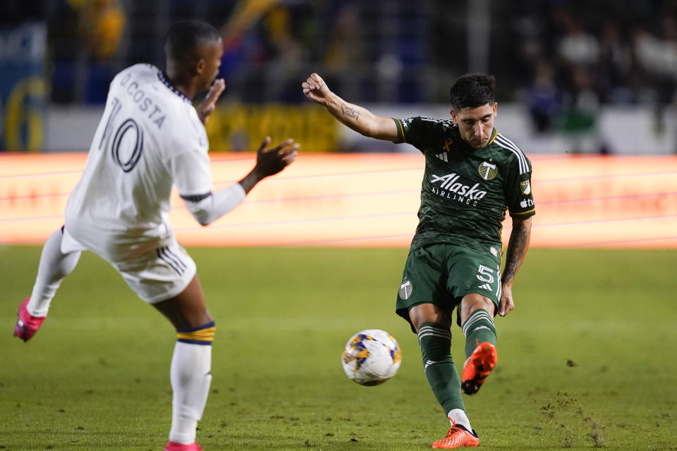 Portland Timbers defender Claudio Bravo, right, clears the ball past LA Galaxy midfielder Douglas Costa during the first half of an MLS soccer match Saturday, Sept. 30, 2023, in Carson, Calif. (AP Photo/Ryan Sun)