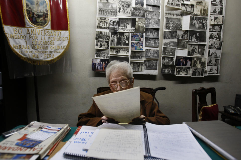 In this Nov. 26, 2012 photo, journalist and radio host Maria Julia Venegas, better known as Maruja Venegas, 97, reads during an interview at her home in Lima, Peru. Venegas who began broadcasting “Radio Club Infantil,” a show for Peru's children in the golden age of radio and World War II, has earned a citation from Guinness World Records as the globe's longest-running radio personality. (AP Photo/Karel Navarro)