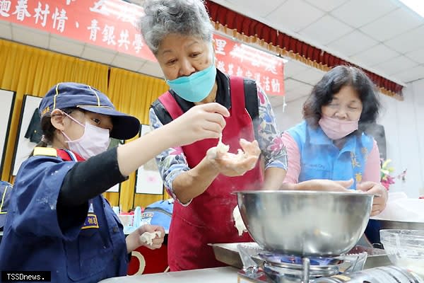 五股貿商里長蕭明霞（右一）促策展上千件眷村文物邀小童軍現製麵疙瘩體驗眷村好味道。<br /><br />（圖：新北民政局提供）