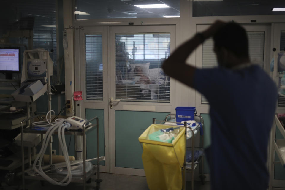 A Medical worker watches a patient affected with COVID-19 inside a Marseille hospital, southern France, Thursday, Sept.10, 2020. As the Marseille region has become France's latest virus hotspot, hospitals are re-activating emergency measures in place when the pandemic first hit to ensure they're able to handle growing new cases. (AP Photo/Daniel Cole)