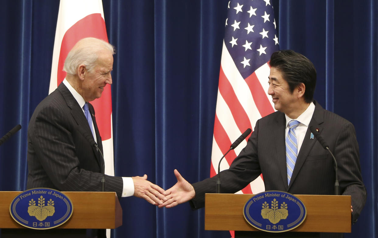 Joe Biden shakes hands with Shinzo Abe.