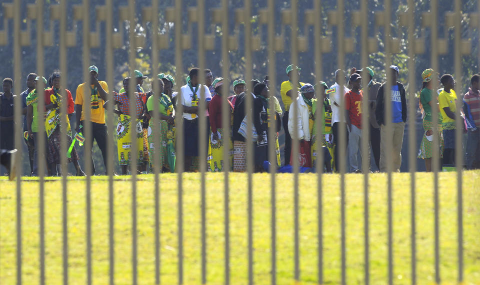People queue to enter the stadium for the inauguration ceremony of Zimbabwean President Emmerson Mnangagwa, at the National Sports Stadium in Harare, Sunday, Aug. 26, 2018. This is the second swearing-in of Mnangagwa in just nine months as a country once jubilant over the fall of longtime leader Robert Mugabe is now more subdued after the reemergence of harassment of the opposition.(AP Photo/Tsvangirayi Mukwazhi)