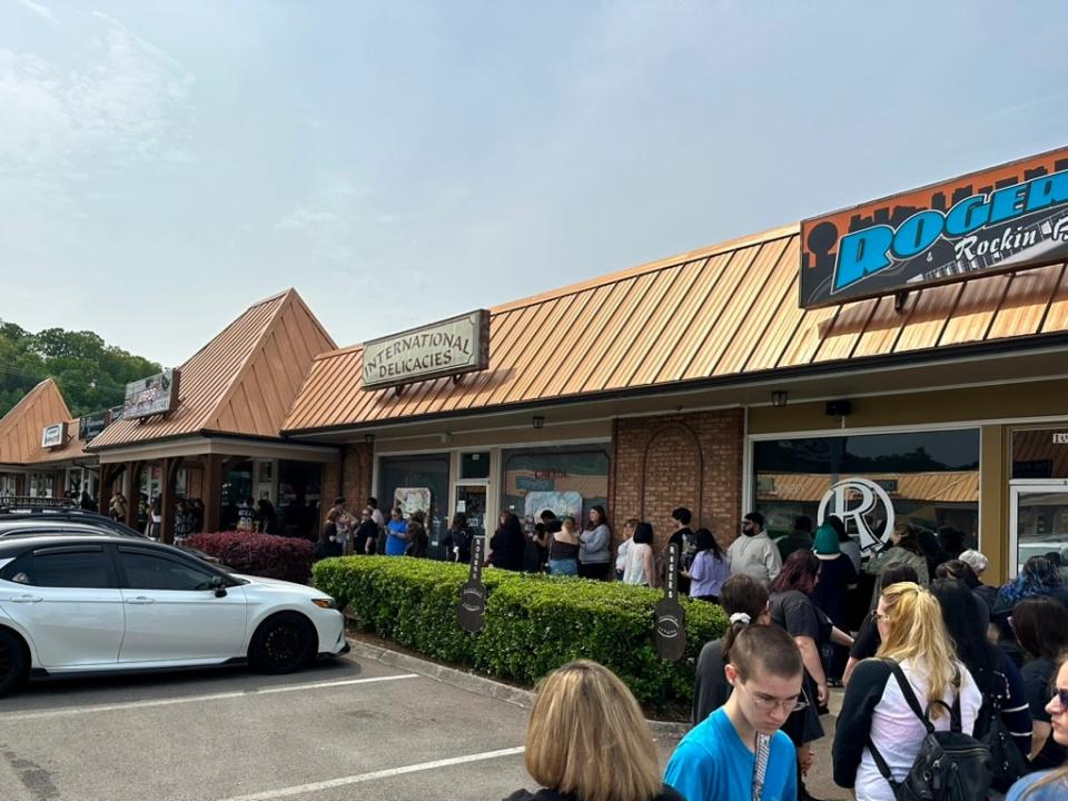 Dozens of eager fans wait in line along the plaza for Ploghvey Kpop’s grand opening on April 27, 2024. The shop’s sign can be seen all the way to the left of the image.