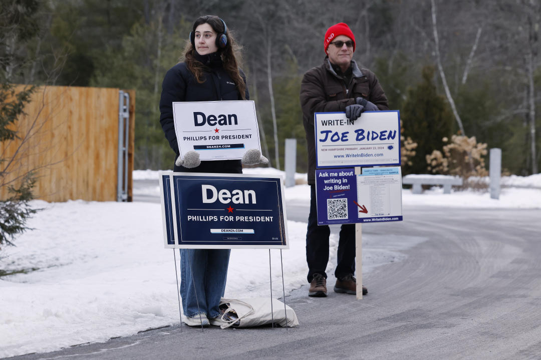 Supporters of Dean Phillips and Joe Biden stand outside a polling place in Concord.