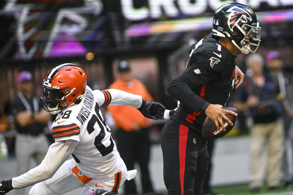 Atlanta Falcons quarterback Marcus Mariota (1) runs out of the pocket as Cleveland Browns linebacker Jeremiah Owusu-Koramoah (28) defends during the first half of an NFL football game, Sunday, Oct. 2, 2022, in Atlanta. (AP Photo/John Amis)