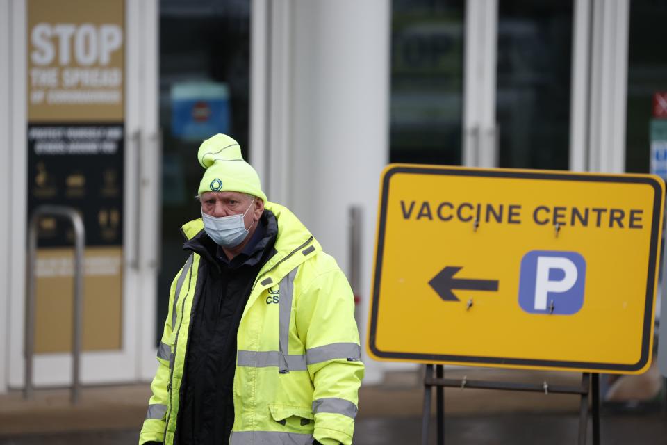 A car park attendant works outside Epsom Downs racecourse as it opens as a Covid-19 mass vaccination centre in Epsom, southern England on January 11, 2021. - Seven mass coronavirus vaccination sites opened across England on Monday as the government races to dose millions of people while a new strain of the disease runs rampant across the country. The sites include football stadiums and a horse racing course, and are located in cities including Bristol, London, Newcastle and Manchester. (Photo by Adrian DENNIS / AFP) (Photo by ADRIAN DENNIS/AFP via Getty Images)