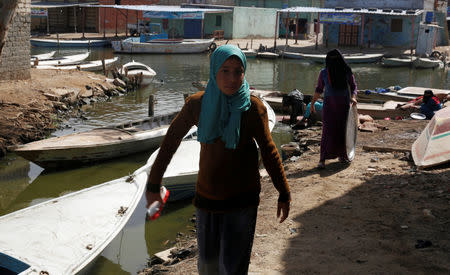 Women of Egypt's Nile Delta village of El Shakhluba carry their household items after washing them in the canal, in the province of Kafr el-Sheikh, Egypt May 5, 2019. Picture taken May 5, 2019. REUTERS/Hayam Adel