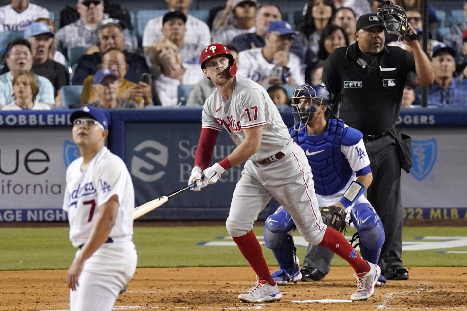 Philadelphia Phillies' Rhys Hoskins, second from left, heads to first as he hits a solo home run as Los Angeles Dodgers starting pitcher Julio Urias, left, and catcher Austin Barnes, second from right, watch along with home plate umpire Adrian Johnson during the fourth inning of a baseball game Saturday, May 14, 2022, in Los Angeles. (AP Photo/Mark J. Terrill)