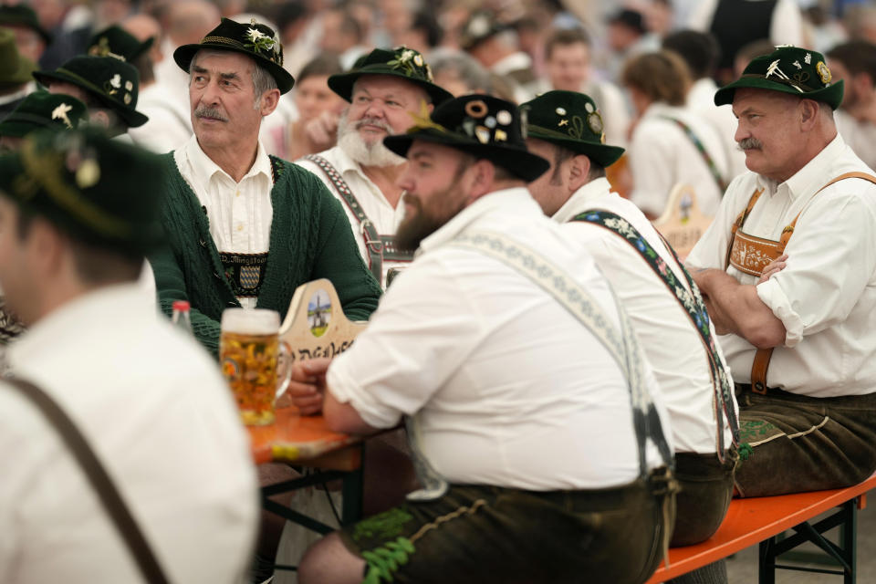 People dressed in traditional clothes attend the German Championships in Fingerhakeln or finger wrestling, in Bernbeuren, Germany, Sunday, May 12, 2024. Competitors battled for the title in this traditional rural sport where the winner has to pull his opponent over a marked line on the table. (AP Photo/Matthias Schrader)