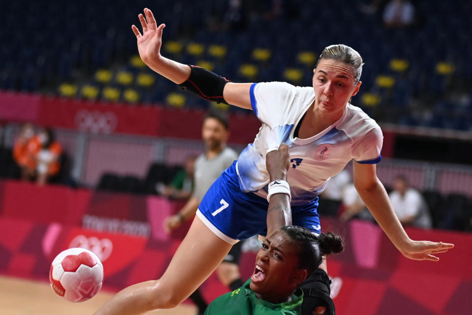 <p>Brazil's pivot Tamires De Araujo (down) is challenged by Russia's centre back Daria Dmitrieva during the women's preliminary round group B handball match between Russia and Brazil of the Tokyo 2020 Olympic Games at the Yoyogi National Stadium in Tokyo on July 25, 2021. (Photo by Daniel LEAL-OLIVAS / AFP)</p> 