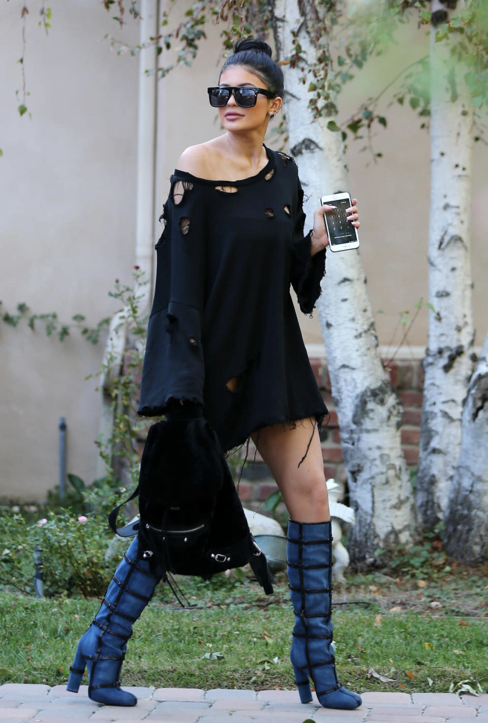 Kylie Jenner wears a shredded shift dress and cage boots in Los Angeles.