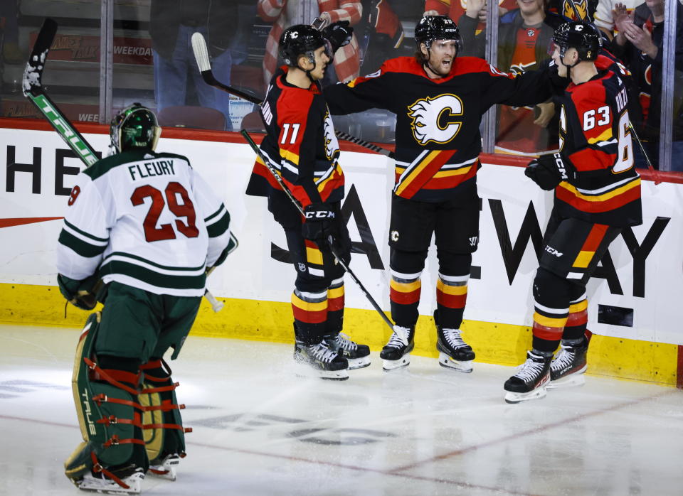 Minnesota Wild goalie Marc-Andre Fleury, left, skates away as Calgary Flames forward Blake Coleman, center right, celebrates his goal during the second period of an NHL hockey game Wednesday, Dec. 7, 2022, in Calgary, Alberta. (Jeff McIntosh/The Canadian Press via AP)