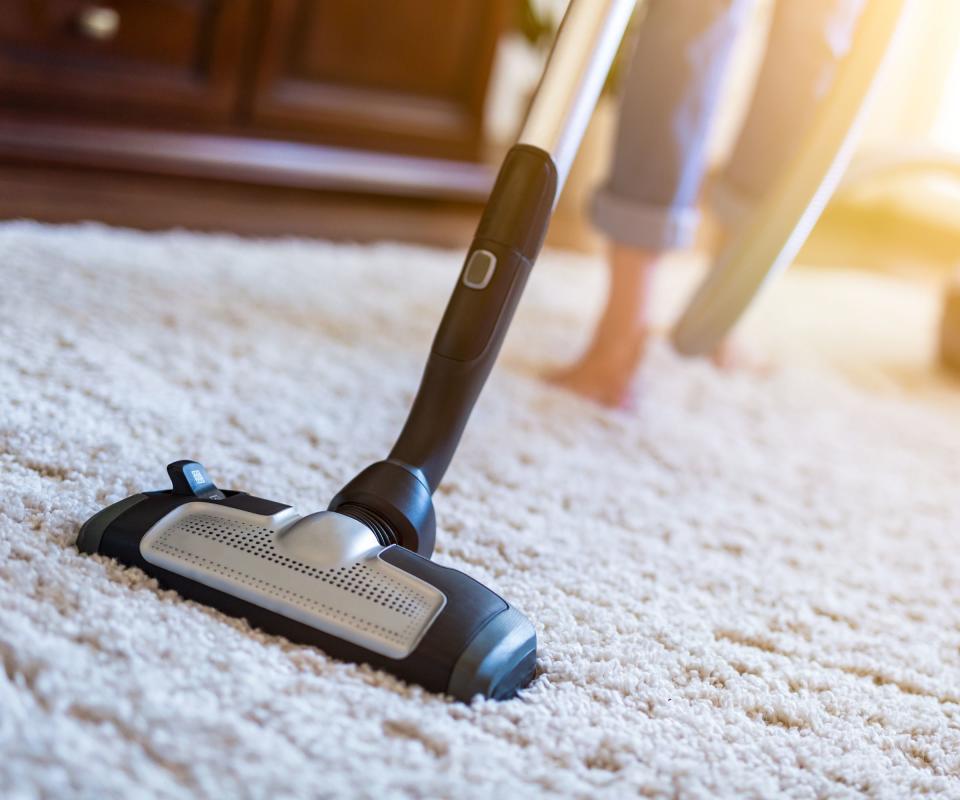 Someone vacuuming the carpet