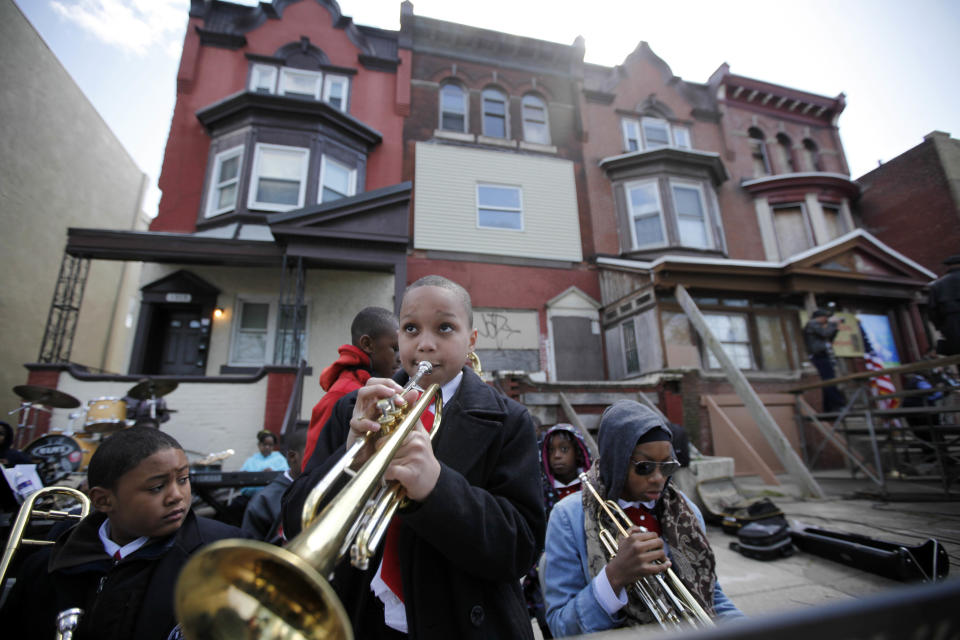 Students play music near the former home, third from left, of jazz musician John Coltrane Friday, April 13, 2012, in Philadelphia. Jazz lovers and cultural officials in Philadelphia are promoting a fundraising effort to save the run-down house. Coltrane lived in a rowhouse in the city's Strawberry Mansion neighborhood from 1952 to 1958. (AP Photo/Matt Rourke)