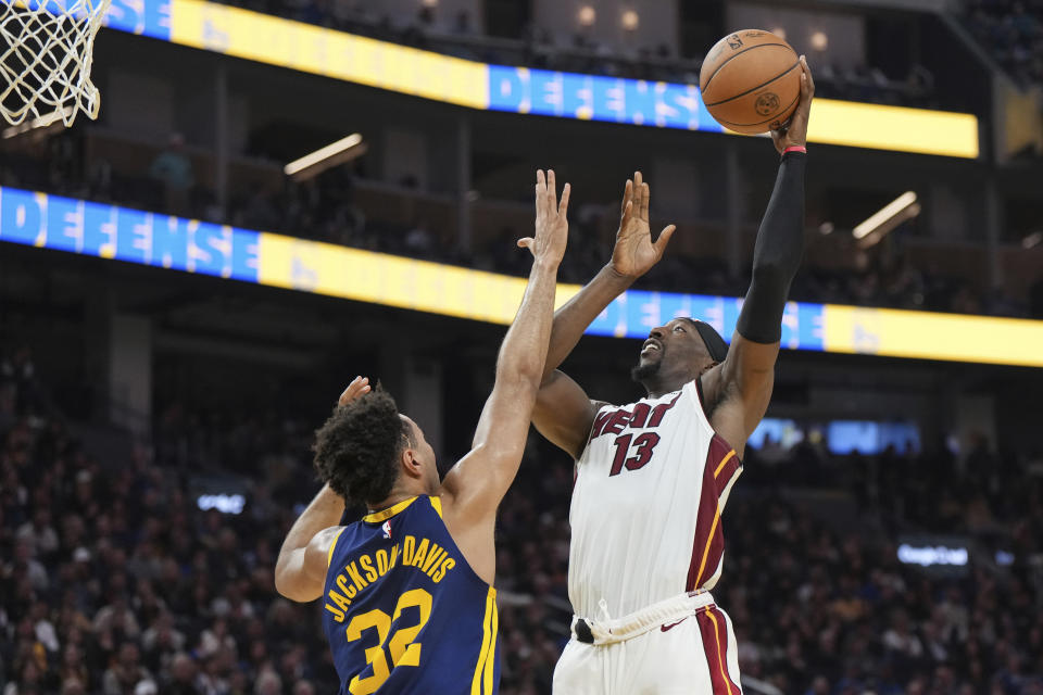 Miami Heat center Bam Adebayo (13) drives to the basket as Golden State Warriors forward Trayce Jackson-Davis (32) defends during the first half of an NBA basketball game Thursday, Dec. 28, 2023, in San Francisco. (AP Photo/Loren Elliott)