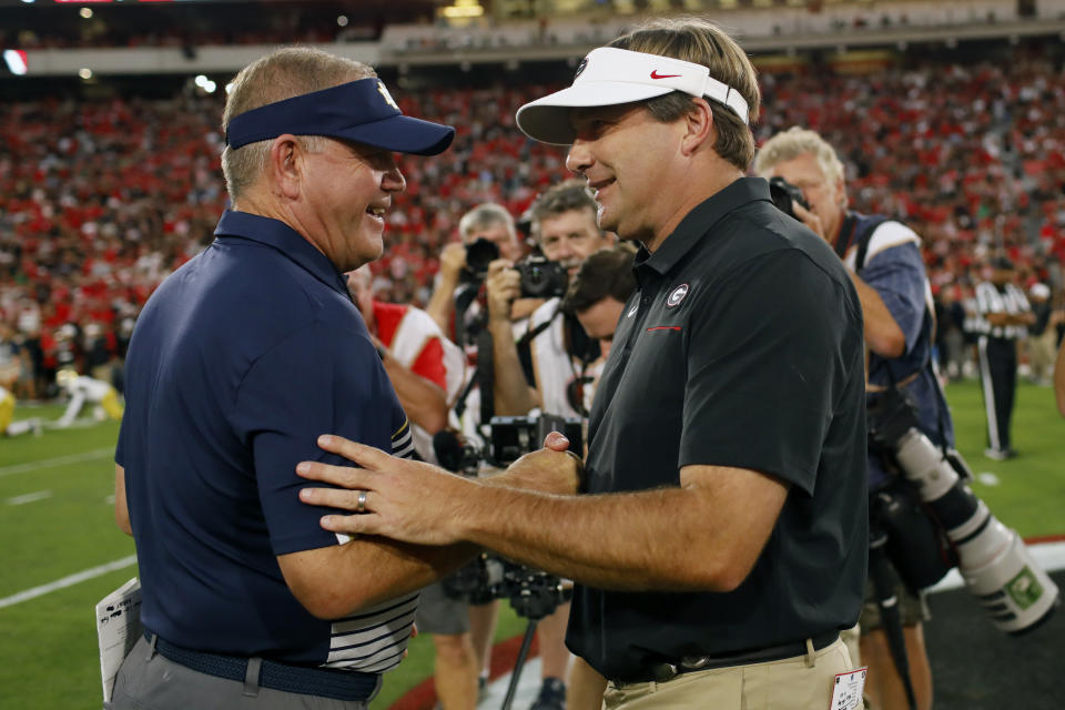 Notre Dame coach Brian Kelly, left, and Georgia coach Kirby Smart, right, shake hands before kickoff of an NCAA football game in Athens, Ga., on Saturday, Sept. 21, 2019. (Joshua L. Jones/Athens Banner-Herald via AP)