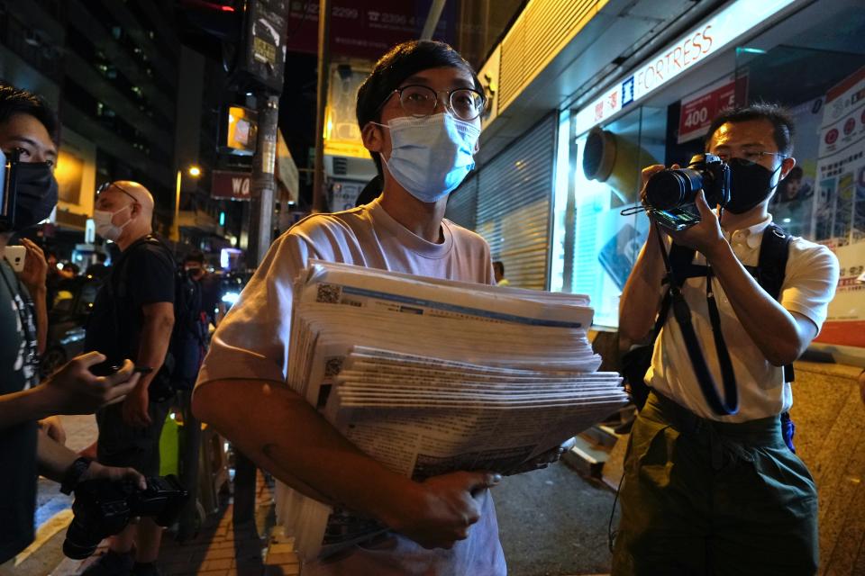 A man holds a stack of last issue of Apple Daily after purchase at a newspaper booth in Hong Kong, early Thursday, June 24, 2021. Hong Kong's pro-democracy Apple Daily newspaper will stop publishing Thursday, following last week's arrest of five editors and executives and the freezing of $2.3 million in assets under the city's year-old national security law. ( AP Photo/Vincent Yu)