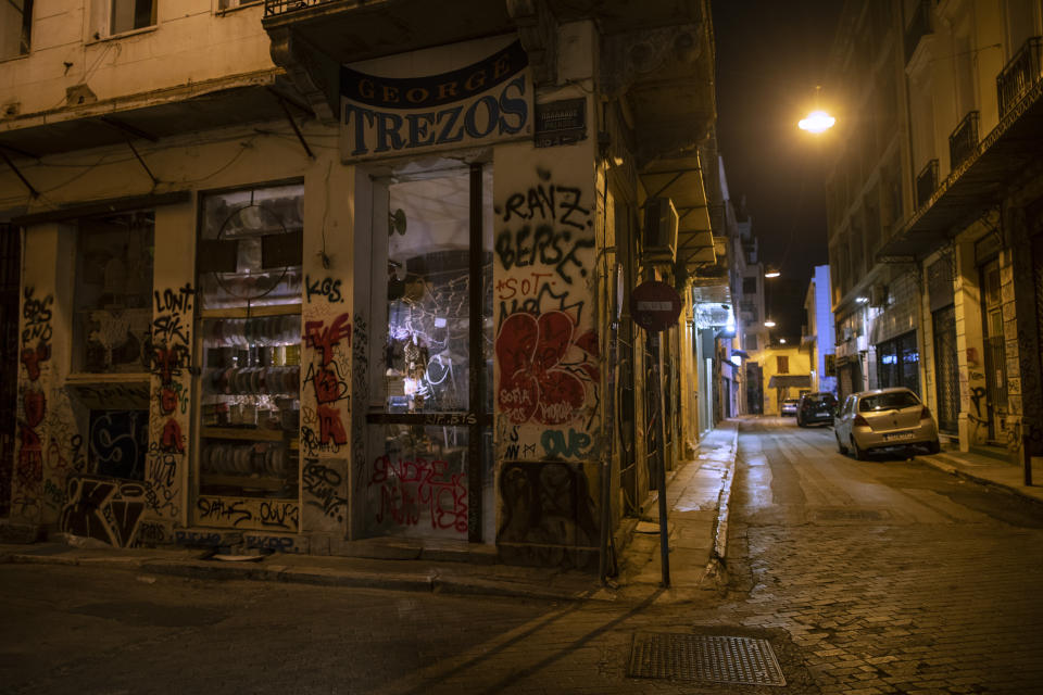 In this Thursday, July 4, 2019 photo, a shop is covered with graffiti in Psiri district , central Athens. Some parts of central Athens are so afflicted with graffiti _ largely undecipherable squiggles in bold, broad strokes _ that few facades remain untouched and property owners give up on repainting. (AP Photo/Petros Giannakouris)