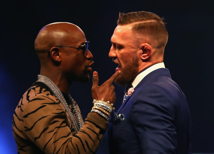 Floyd Mayweather (L) and Conor McGregor talk to each other during the last stop of their four-city, three-country tour. (Getty)