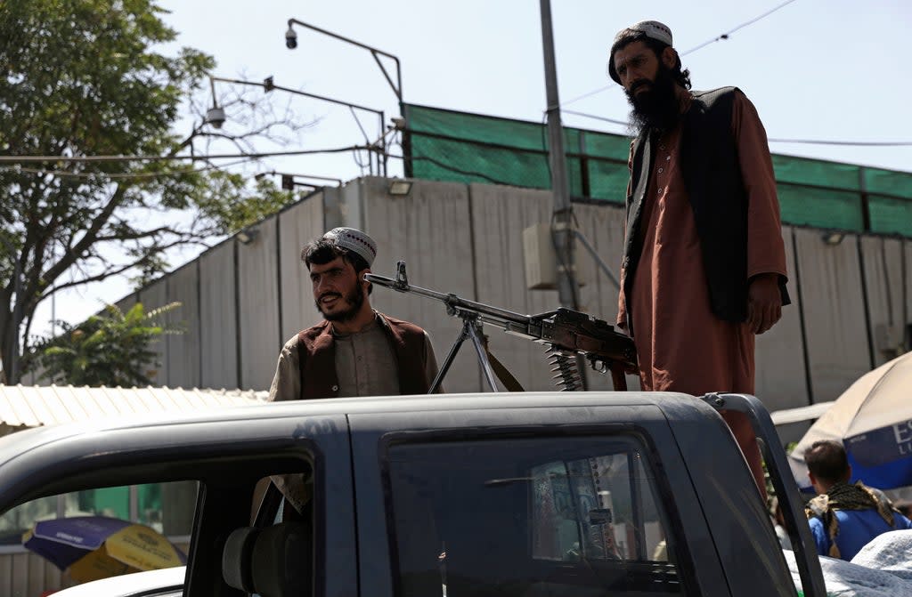 Taliban fighters stand guard on the back of vehicle in Kabul (Rahmat Gul/AP/PA) (AP)